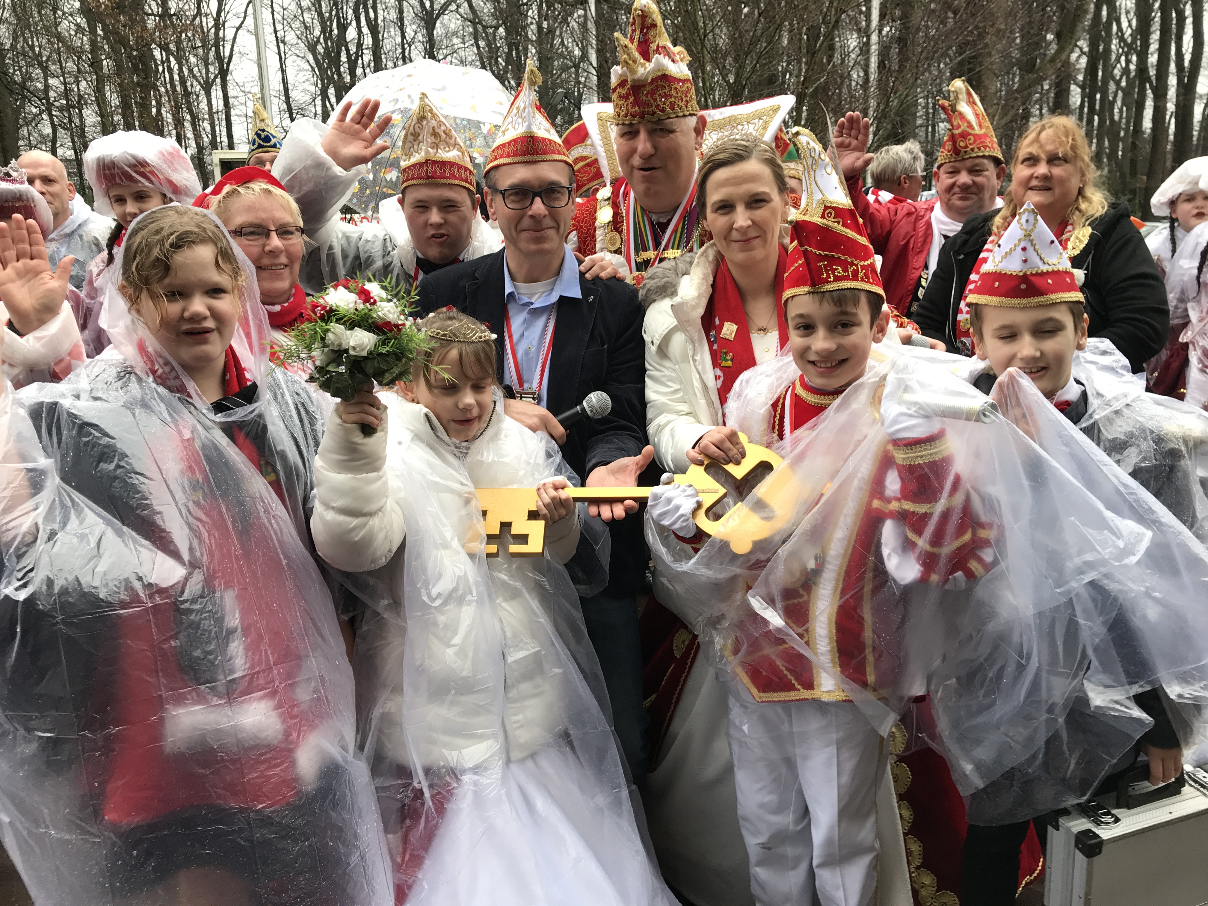 Das Bild zeigt Bürgermeister André Dora mit Karnevalist*innen der KG Rot-Weiß beim Rathaussturm 2019.