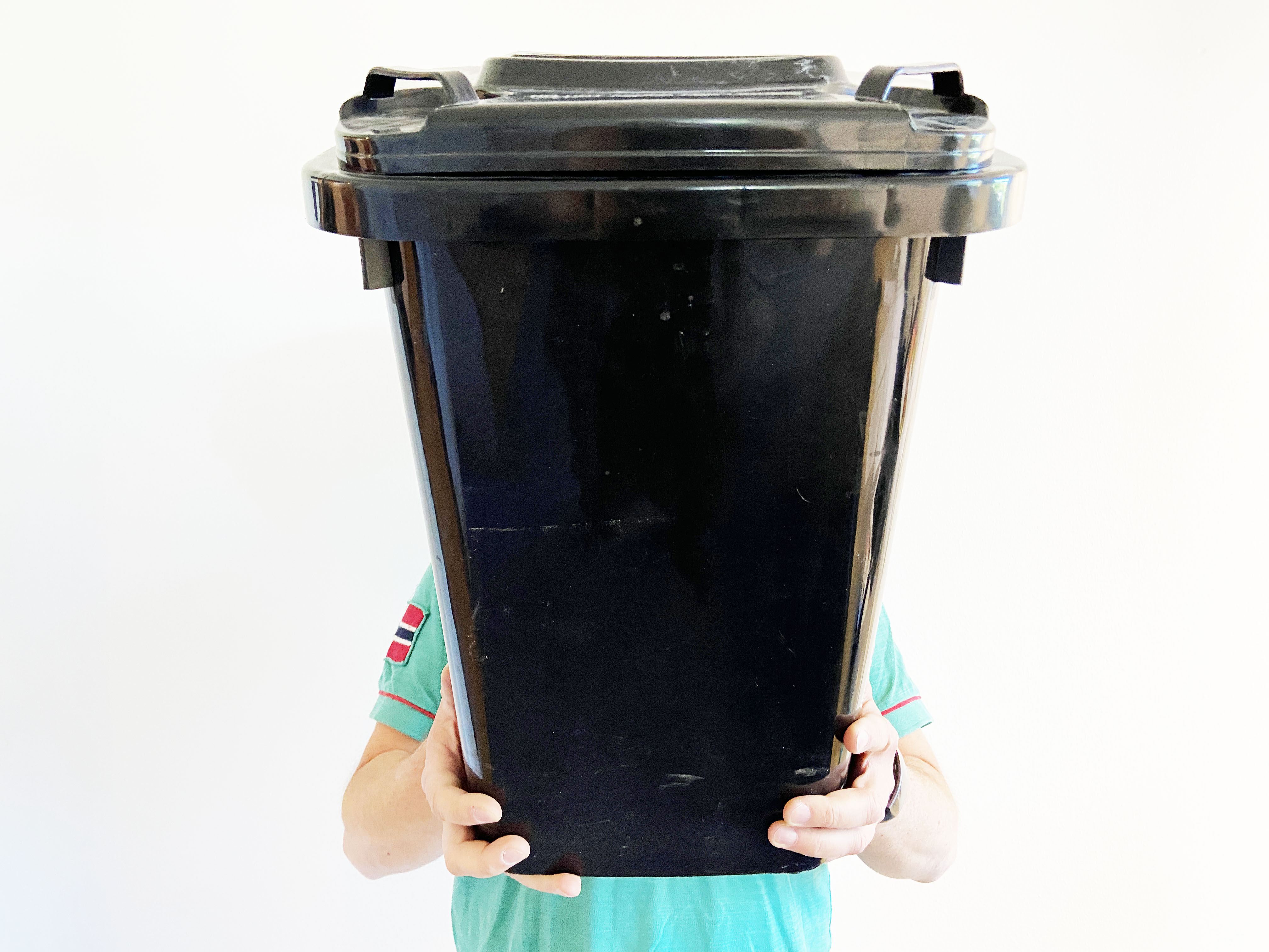 Das Bild zeigt einen Mitarbeiter des KSD, der sich hinter einer Mini-Mülltonne "versteckt"