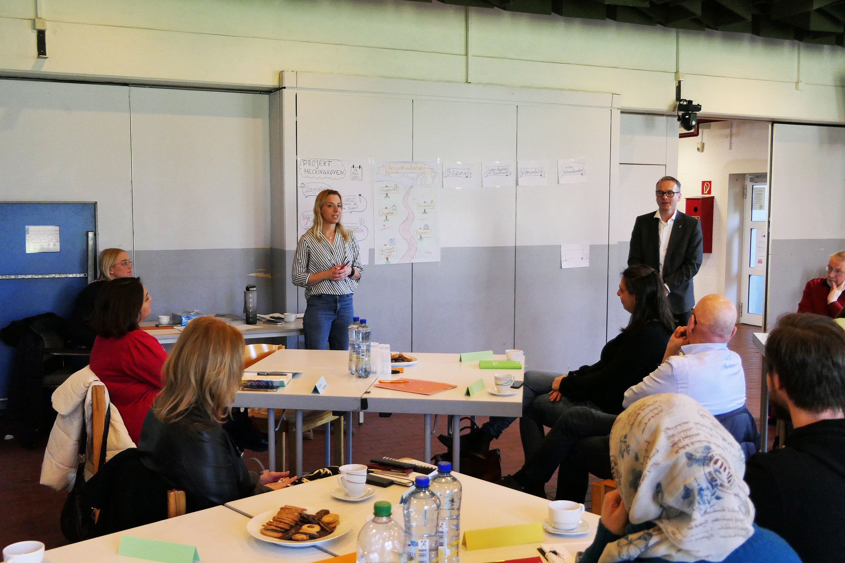 Das Bild zeigt im Hintergrund Bürgermeister André Dora (rechts) und daneben Anika Klein vom Jugendamt.