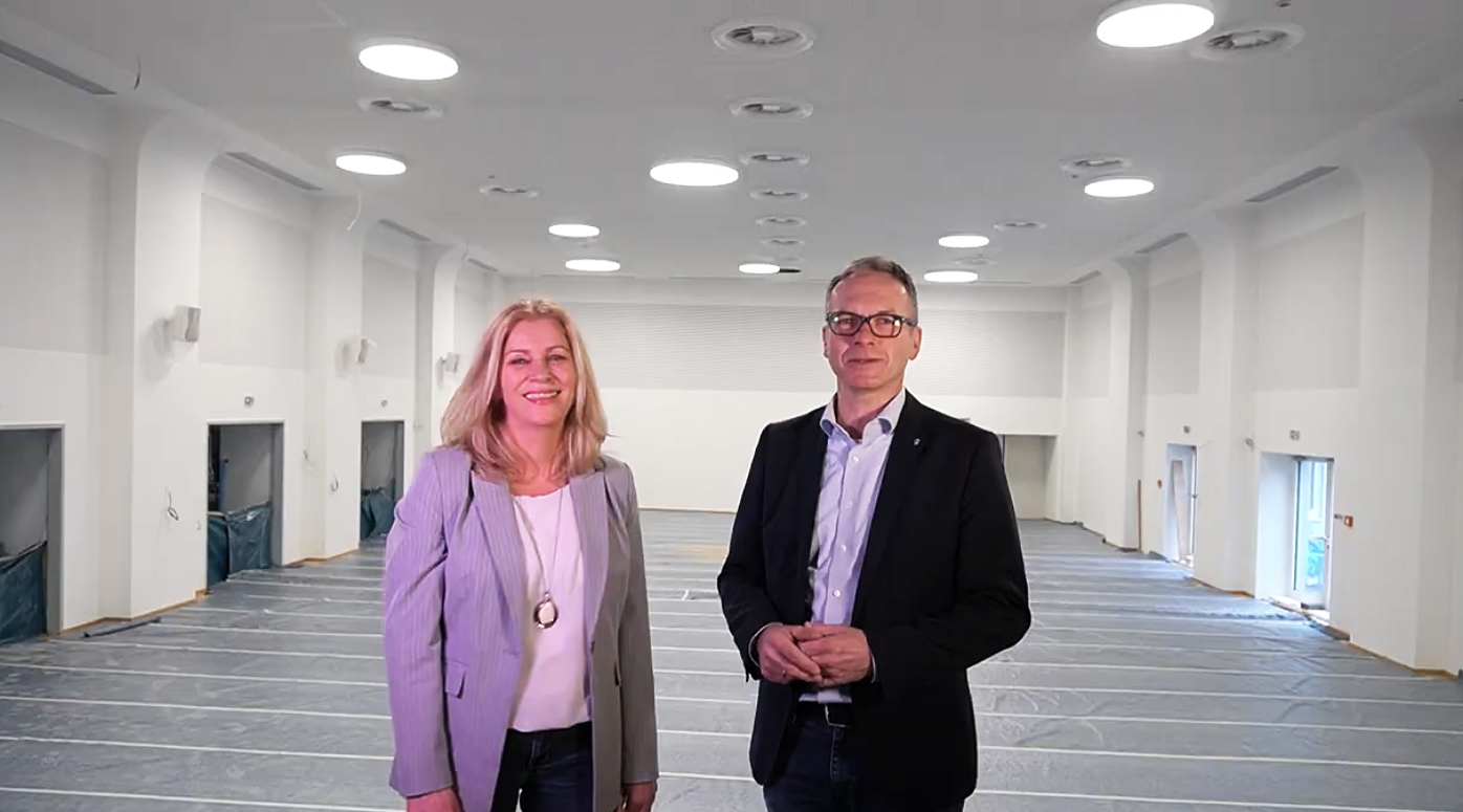 Das Bild zeigt links Musikschulleiterin Kristin Seifert und rechts Bürgermeister André Dora auf der Bühne der Stadthalle.