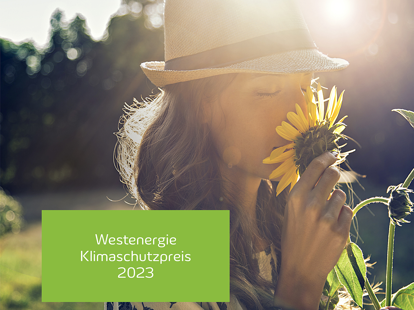 Frau, die an einer Sonnenblume riecht. Im Hintergrund geht die Sonne unter.