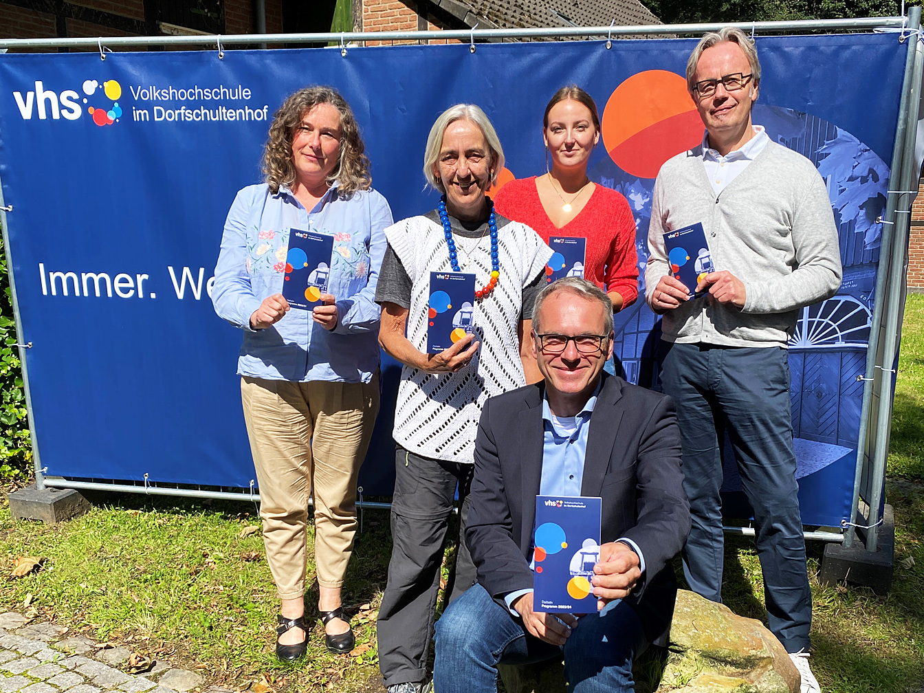 Von links sind zu sehen Patricia Gerards, Rosemarie Schloßer, Svenja Falk, Bürgermeister André Dora und Dezernent Michael Hans, die das Programmheft der VHS zeigen.