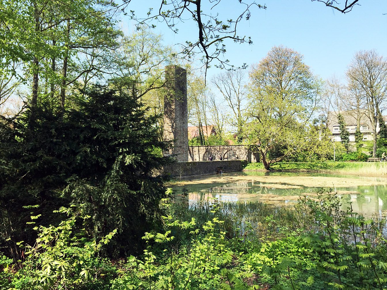 Ehrenmal an der Castroper Straße, im Vordergrund ein Teich, ringsherum Bäume und Sträucher.