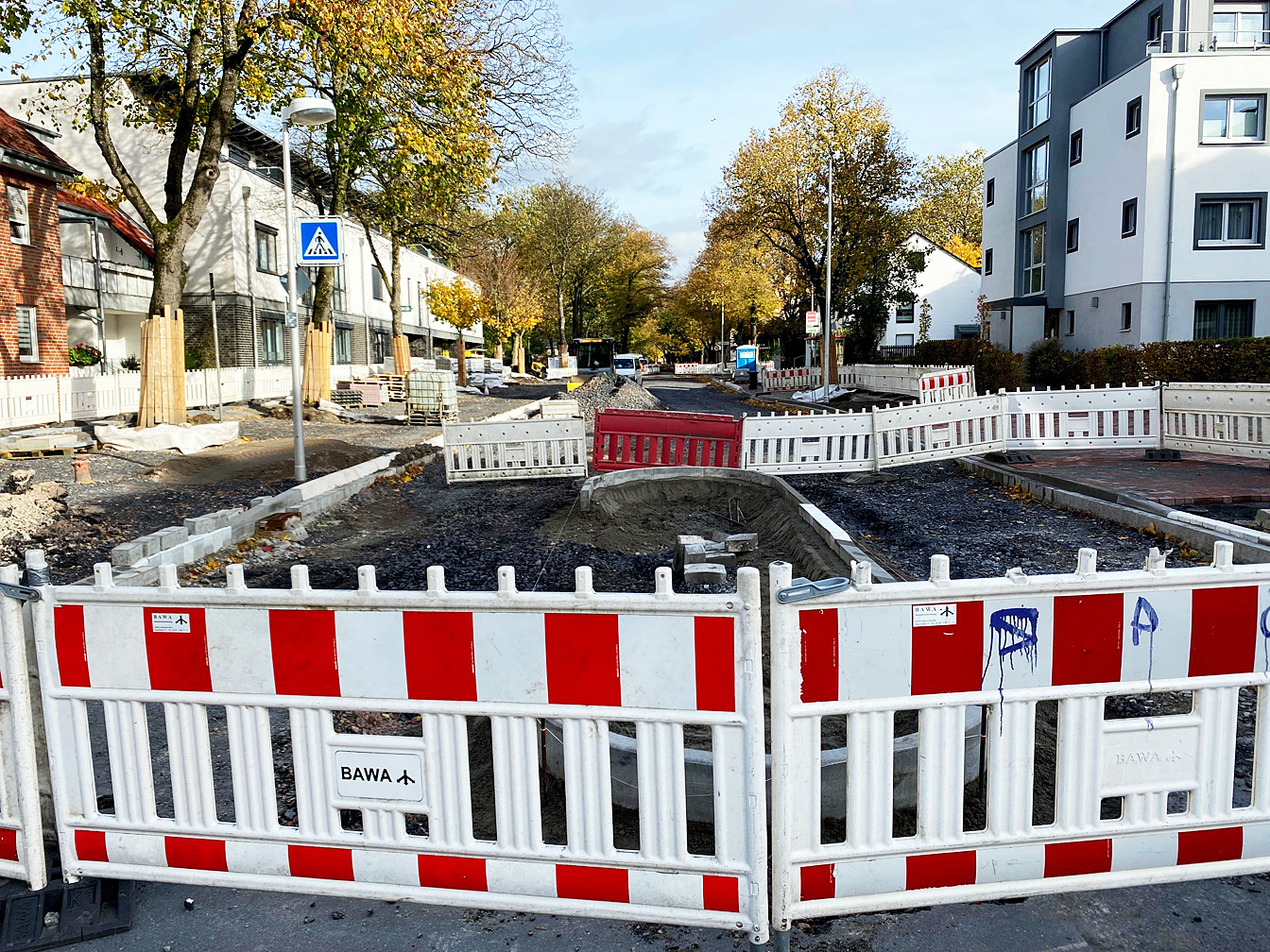 Im Vordergrund stehen Absperrbaken, dahinter Baustellenbetrieb auf der Hafenstraße Richtung Südring.