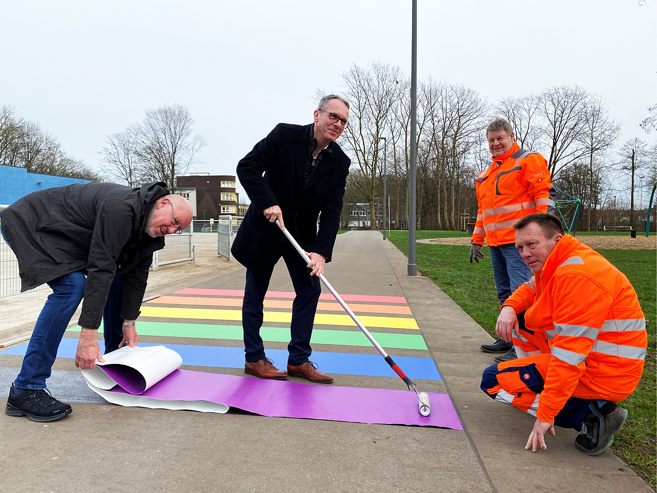 Ralf Feldhaus (Ordnungsamt), Bürgermeister André Dora sowie Thomas Burow und Thomas Wesselbaum vom Kommunalen Servicebetrieb Datteln - KSD beim Anbringen der Regenbogenstreifen im Sportpark Mitte.