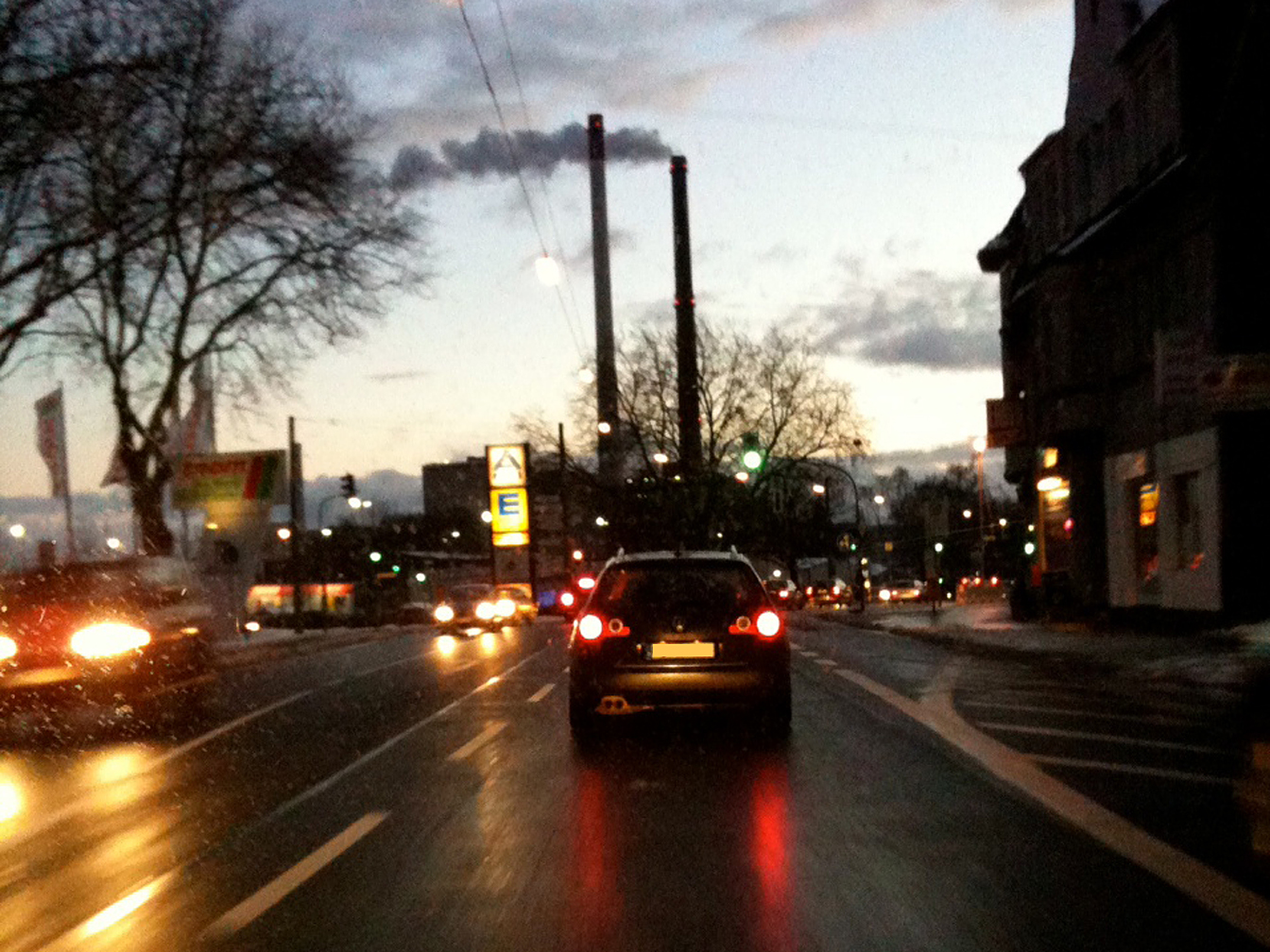 Abendlicher Stimmung mit Fahrzeugen auf der Castroper Straße am Zechenberg - im Hintergrund sind noch die beiden Schornsteine von Datteln 1-3 zu sehen. 