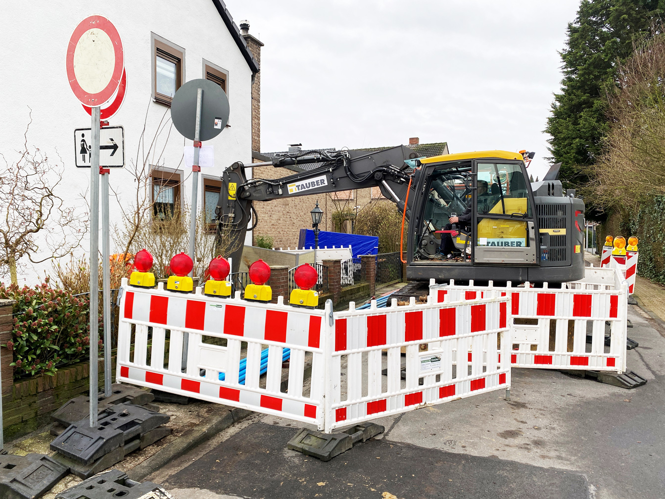 Baustellenabsperrung mit Schildern und einem Bagger, der die Baugrube für die Suche nach dem Blindgänger aushebt.