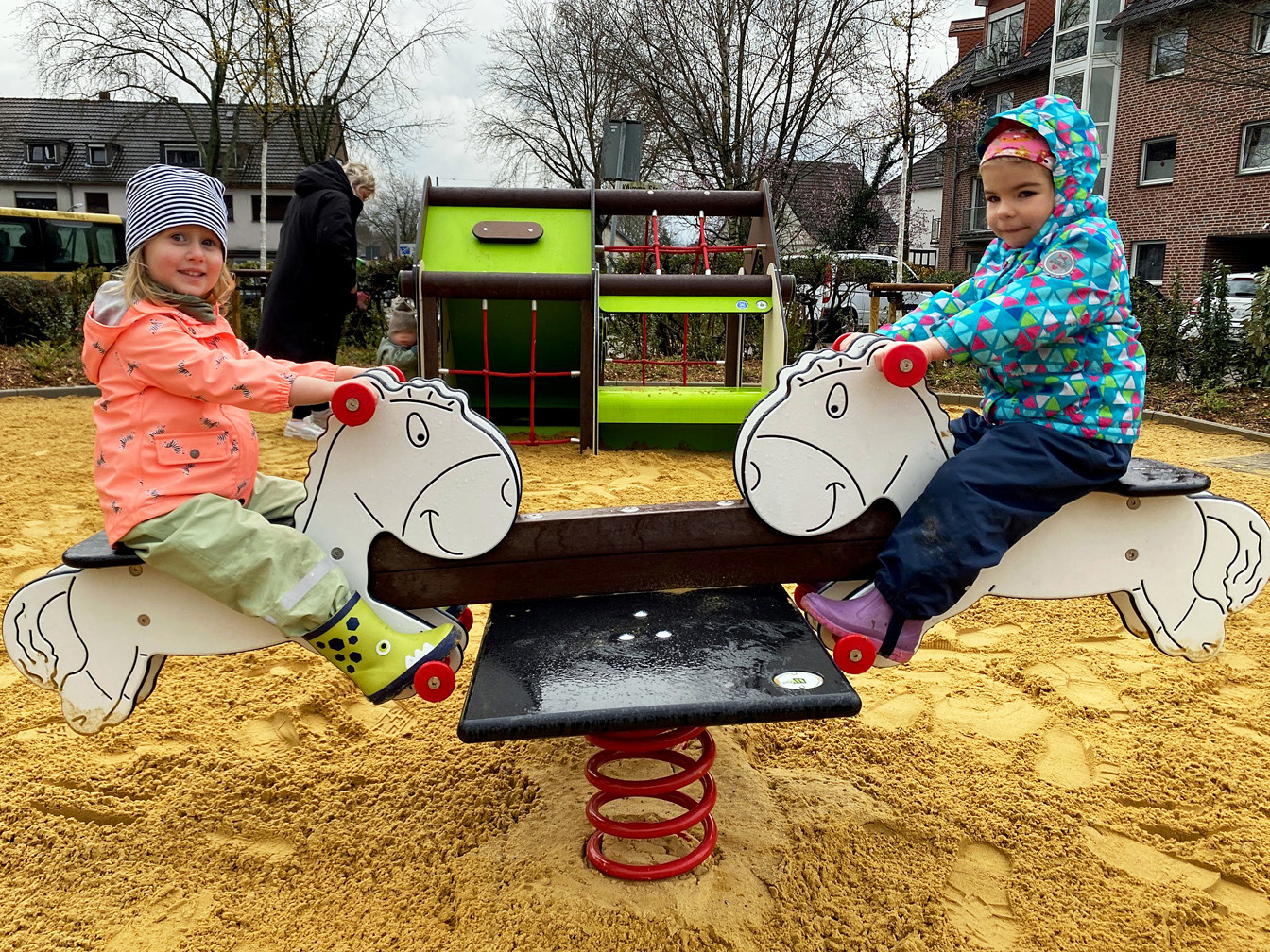 Zwei Kinder (Mia und Romi) auf einer Wippe auf dem Spielplatz an der Markstraße