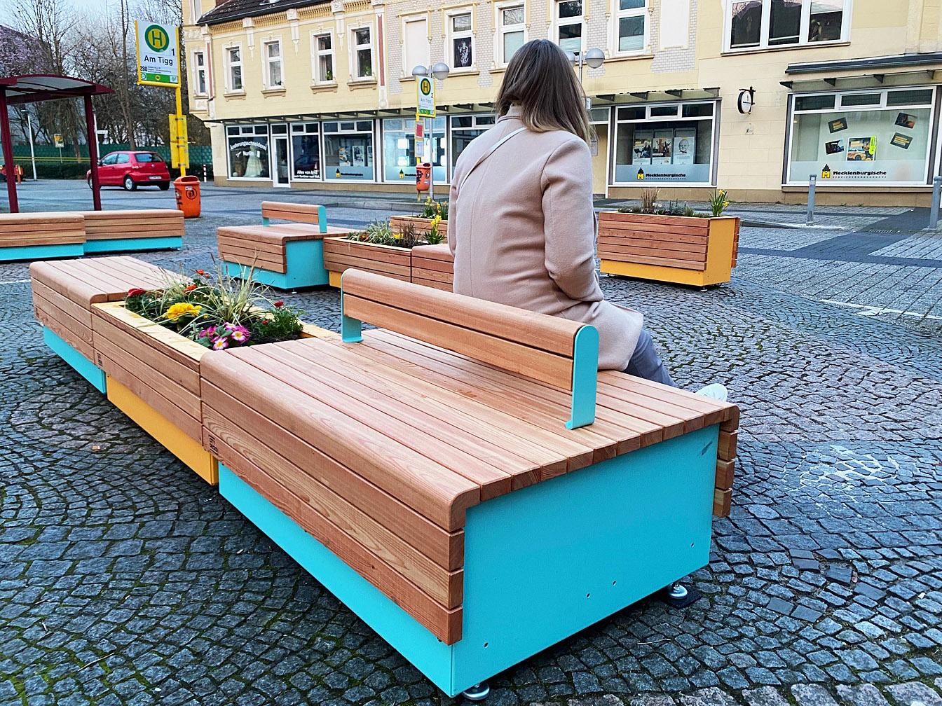 So genannte Stadtmöbel auf dem Tigg, auf denen eine Frau sitzt.