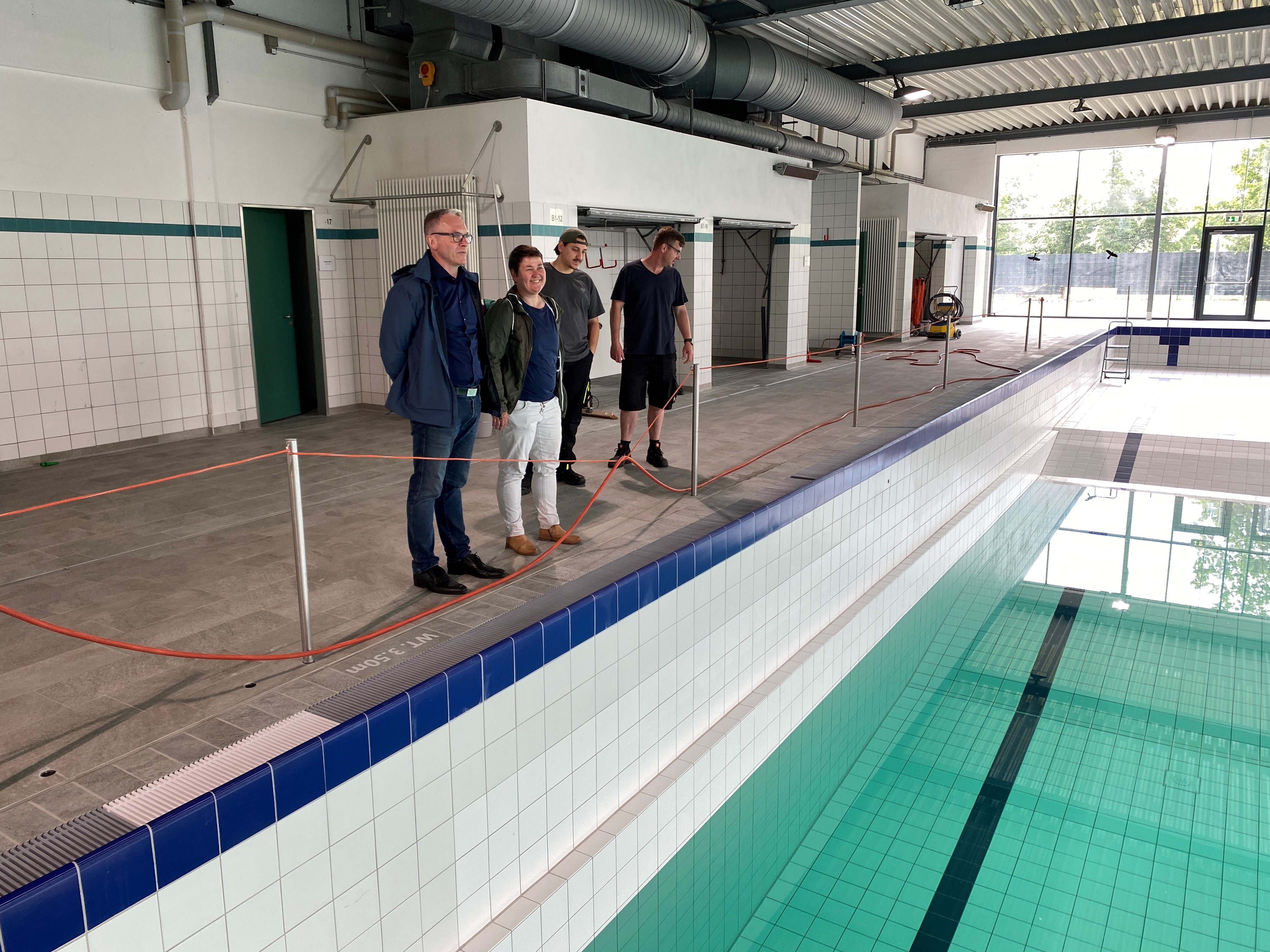 Bürgermeister André Dora besichtigt mit Mitarbeiter*innen das Wassereinlassen im sanierten Stadtbad