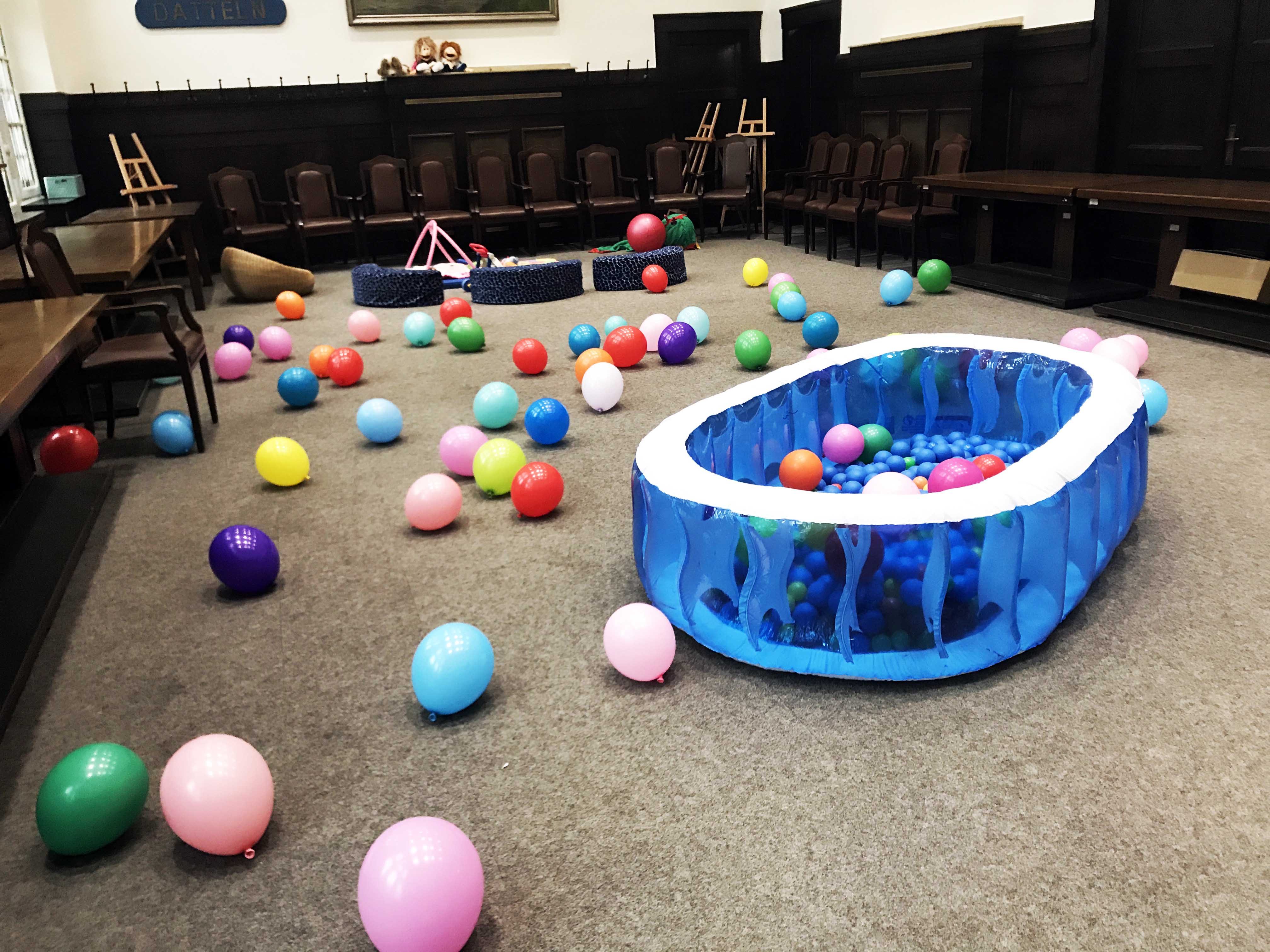 Der ausgeräumte Sitzungssaal mit Bällen und einem Plastikplanschbecken