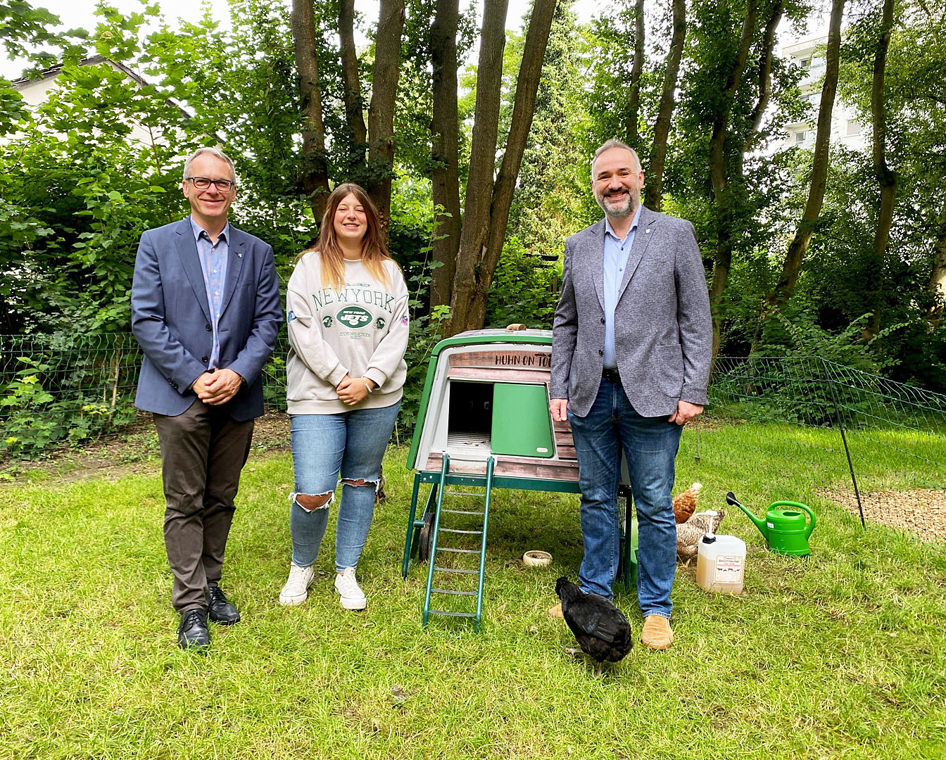 Bürgermeister André Dora, Kita-ARTIKUS-Leiterin Kim Starschinski und Dr. Marco Zerwas stehen vor dem Hühnermobil.