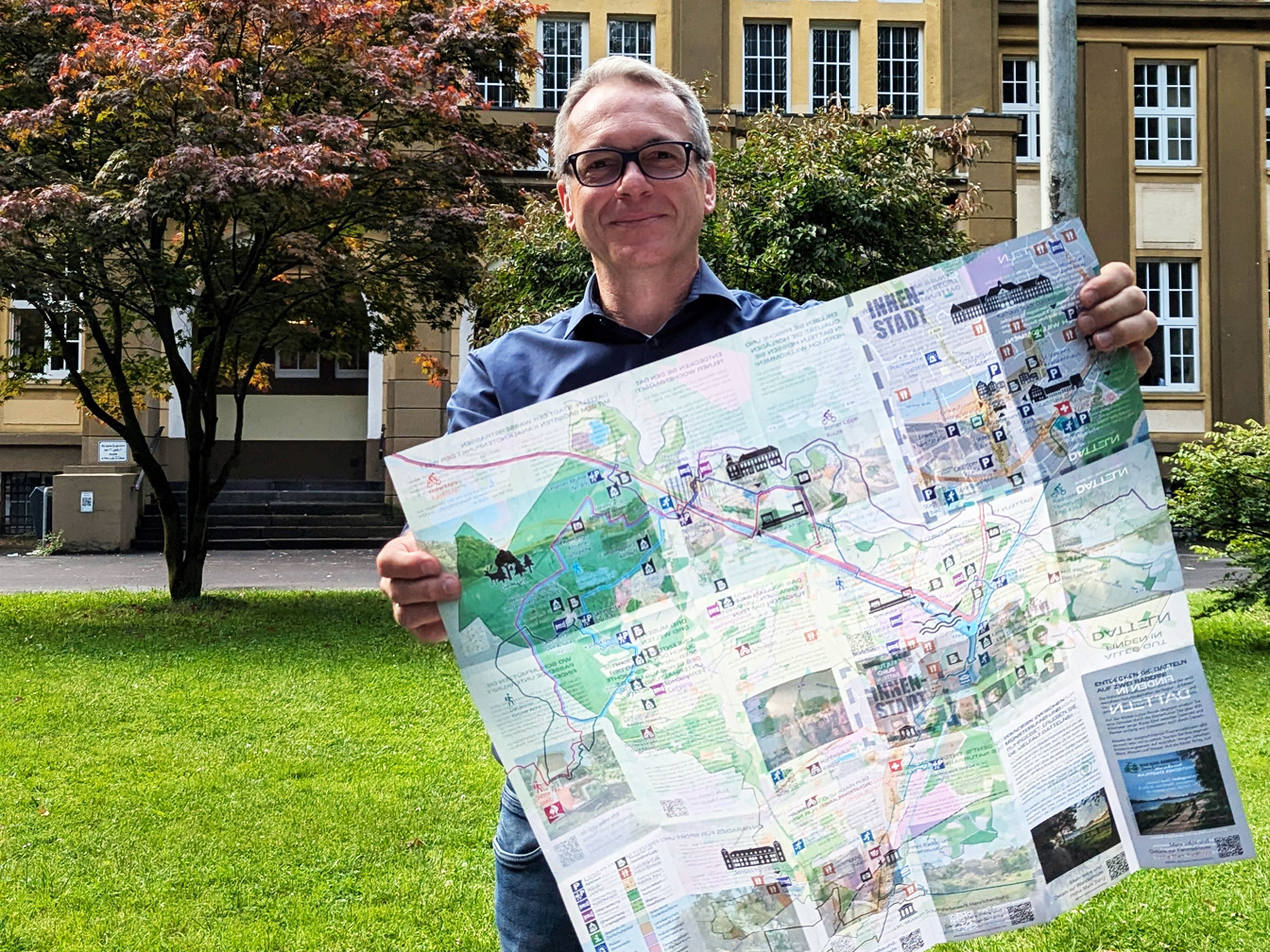 Andre Dora präsentiert den touristischen Stadtplan vor dem Dattelner Rathaus