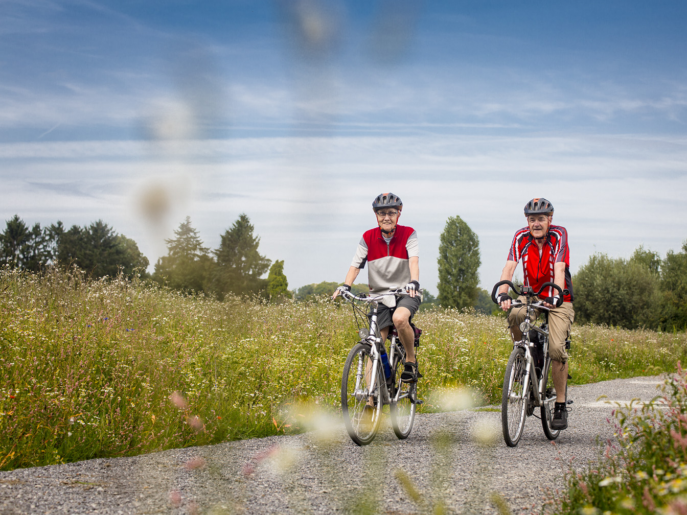 Zwei Radfahrer*innen machen eine Tour im Grünen.