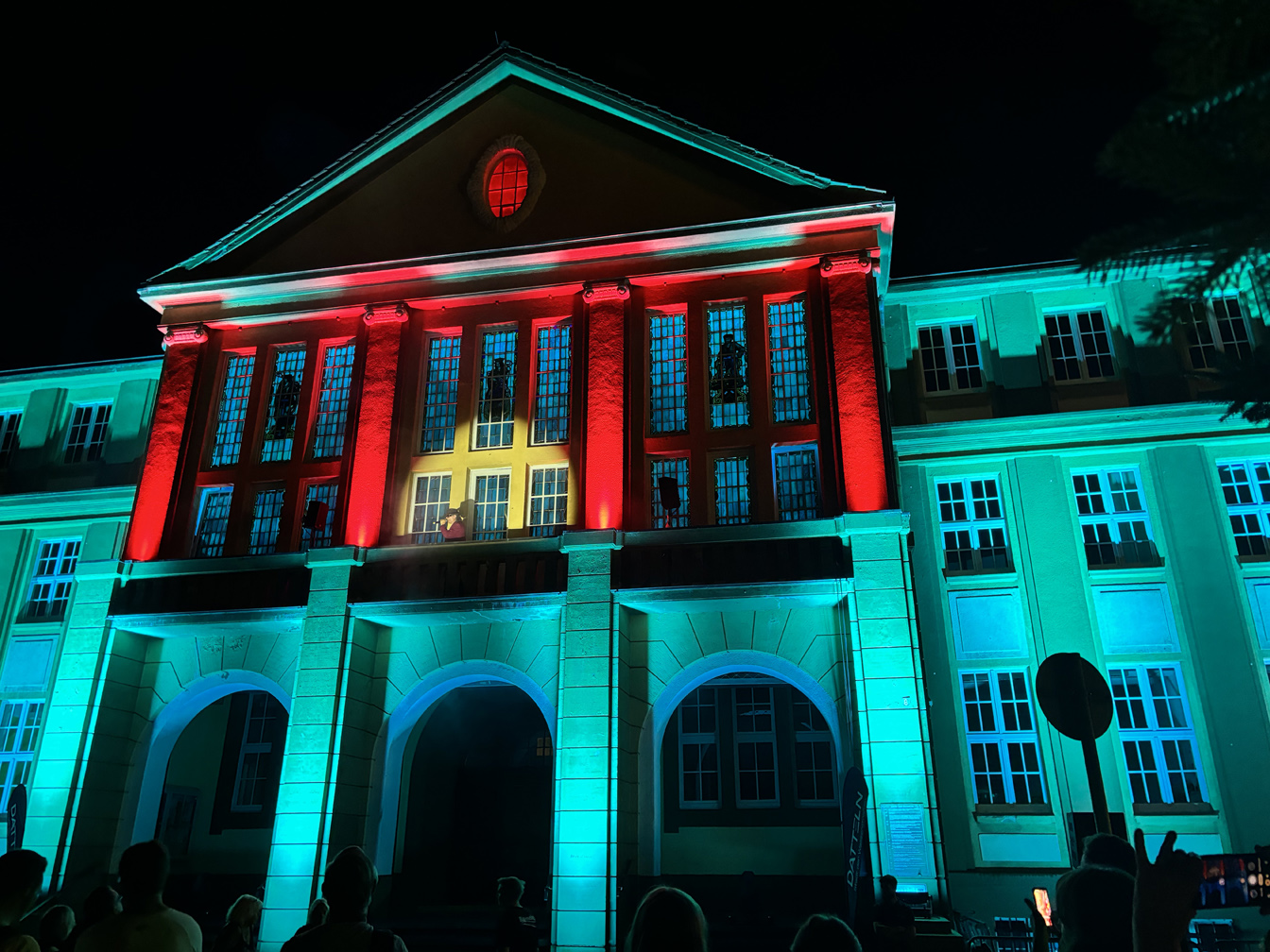 Rathausfest im Licht 2024 mit Udo-Lindenberg-Double Karsten Bald auf dem Balkon des beleuchteten Rathauses
