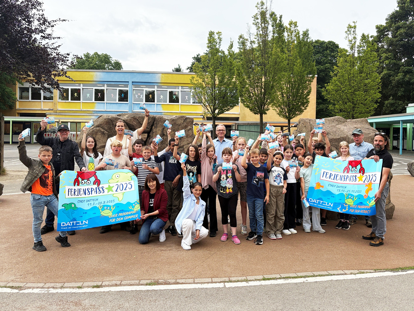 Bürgermeister André Dora zusammen mit der 4b, ihrer Klassenlehrerin Nicole Gerhards, Mitarbeiter*innen der Stadtverwaltung und Karsten Schulte, Inhaber der Kreativ Medien Service GmbH, die das Heft gestaltet und gedruckt hat.
