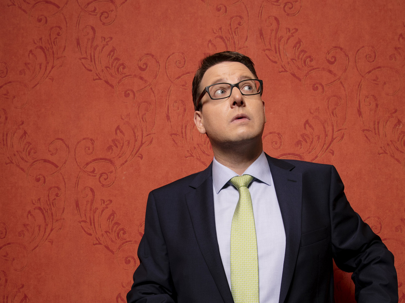 Das Bild zeigt Kai Magnus Sting vor einer rot tapezierten Wand.