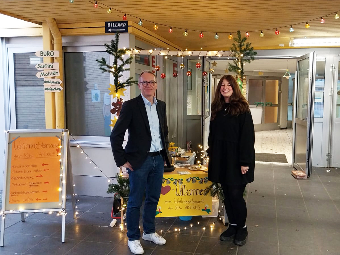 Bürgermeister André Dora und Kim Starschinski, Leiterin des städtischen Familienzentrums Artikus, am Eingang des Weihnachtsmarkts.