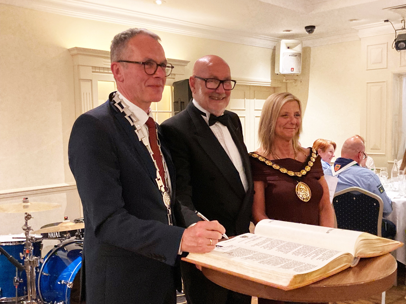 Bürgermeister André Dora, Julie Aston (Vorsitzende des Rates von Cannock Chase) und Ratsführer Steve Thornley tragen sich in das Goldene Buch ein.