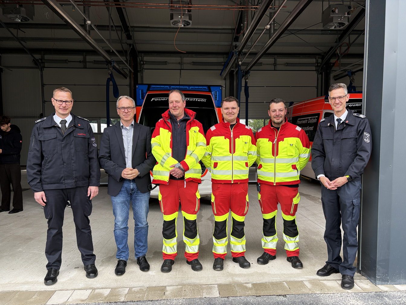 Bürgermeister André Dora mit dem Leiter der Feuerwehr und seinem Stellvertreter sowie drei Personen vom Rettungsdienst in der neuen Rettungswache.