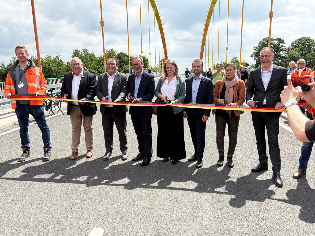 Mehrere Personen schneiden ein schwarz-rot-goldenes Band auf dem Dattelner-Meer-Bogen durch.