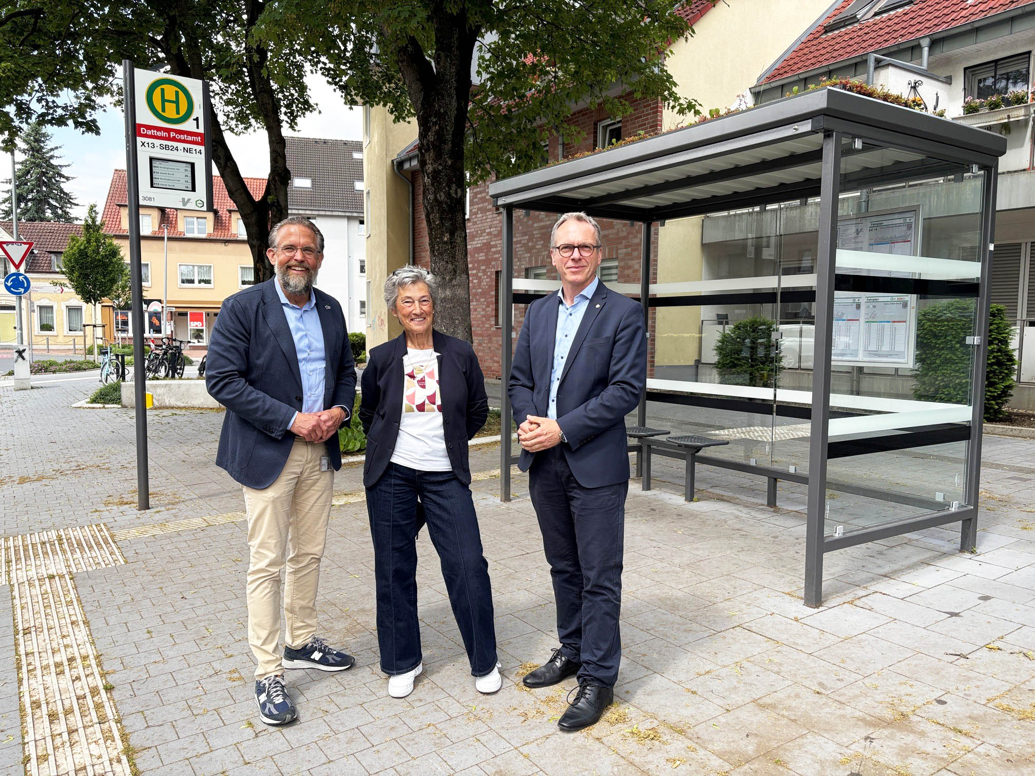 Drei Personen stellen an der Haltestelle Postamt das Projekt "Mobil ohne Auto" vor.