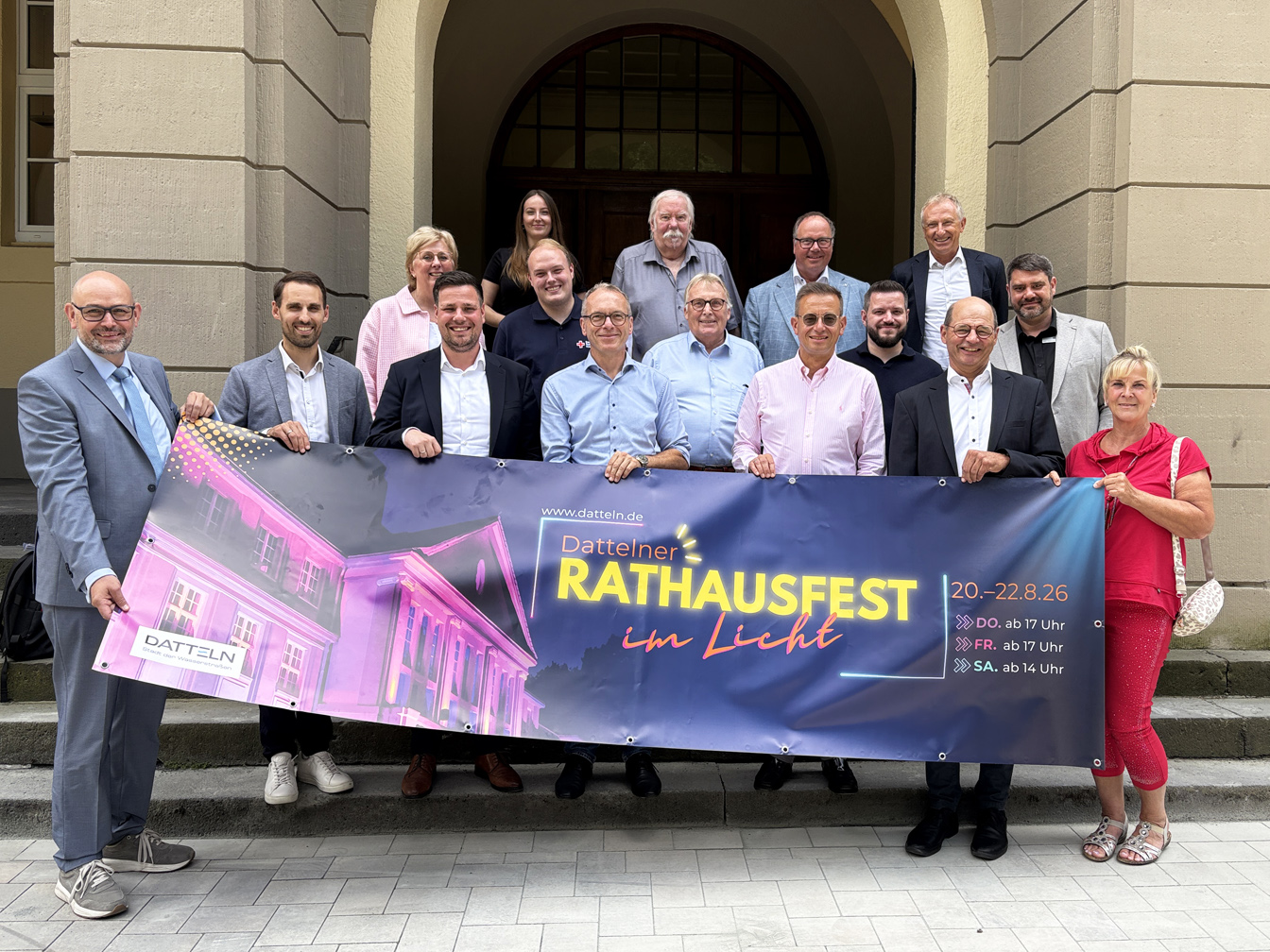 Stadtverwaltung und Sponsoren vor dem Rathaus mit Banner zum Rathausfest