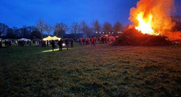 Menschen stehen an einem großen Osterfeuer