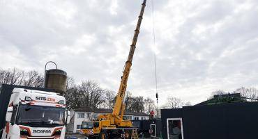 Ein Raummodul für die Übergangsrettungswache hängt am Haken