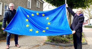 Bürgermeister André Dora und Rosemarie Schloßer mit einer Europafahne an der Cannockstraße