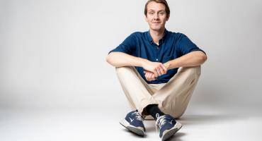 Das Bild zeigt Jonas Greiner, der auf dem Boden sitzt