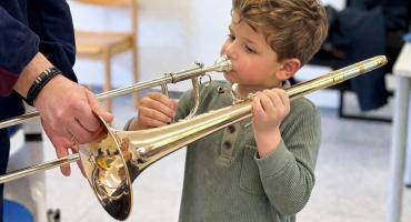 Ein Junge probiert eine Posaune aus.