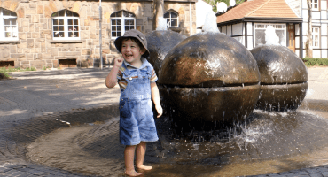Kind am Tigg-Brunnen - Hinweis: Das Gesicht wurde mit KI geändert