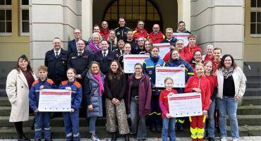 Das Team EFA mit Spendenempfänger*innen und Bürgermeister vorm Dattelner Rathaus