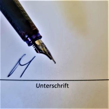 Das Bild zeigt einen Füller der eine Unterschrift leistet.