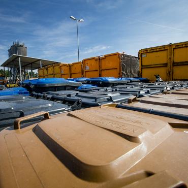 Das Bild zeigt diverse Mülltonnen auf dem Gelände des Recyclinghofs.