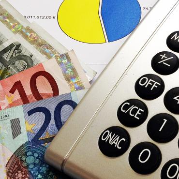 Das Bild zeigt Geldscheine und einen Taschenrechner