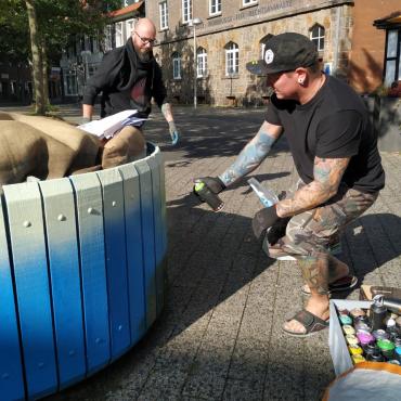 Das Foto zeigt eine Sprayaktion an einem Blumenkübel.