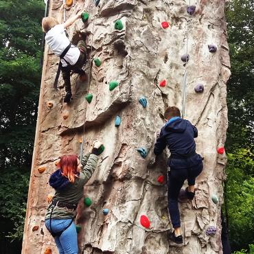 Das Bild zeigt Schüler*innen, die einen Turm hochklettern.