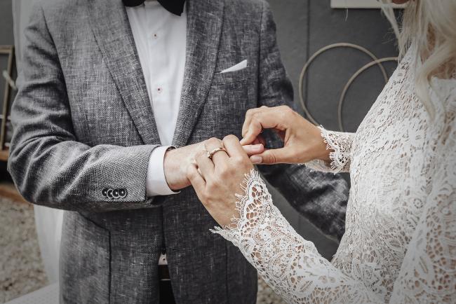 Das Bild zeigt ein Brautpaar beim Ringtausch.