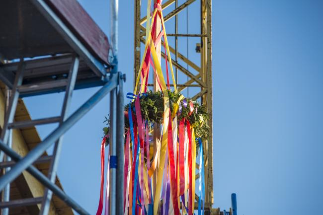 Das Bild zeigt einen Richtkranz in einem Baugebiet.