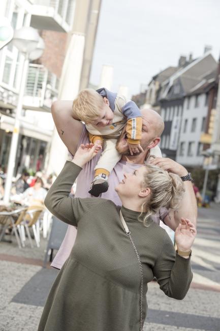 Das Bild zeigt eine Familie in der Innenstadt. 