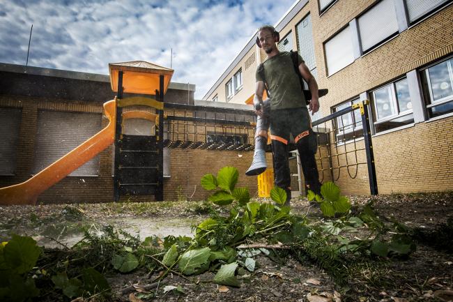 Das Bild zeigt einen Arbeiter mit einen Laubbläser.