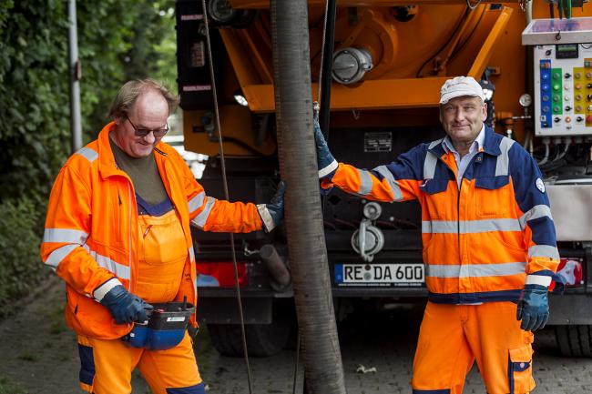 Hier sieht man zwei Arbeiter bei der Entwässerung.