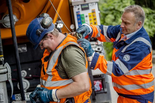 Hier sieht man zwei Arbeiter bei der Entwässerung.