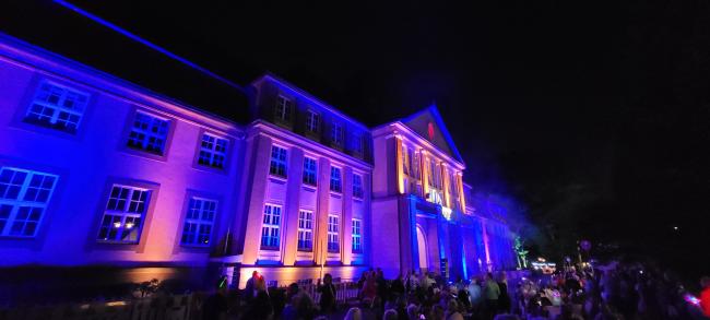 Das Bild zeigt das blau illuminierte Rathaus. 