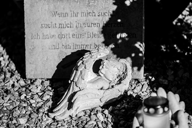 Das Bild zeigt einen Engel auf einem Grab. 