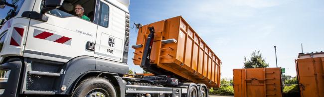 Das Bild zeigt das Abladen eines Wertstoffcontainers