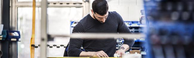 Das Bild zeigt einen Arbeiter in einem Fensterbetrieb