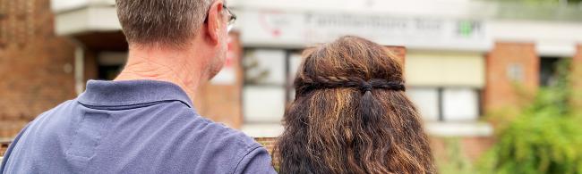 Das Bild zeigt ein Pflegeelternpärchen von hinten